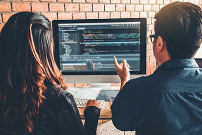 Ocean County website designer working with assistant looking at a screen of computer code
