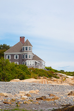 Coastal style home shown on a rocky beach; Mantoloking home on the shoreline